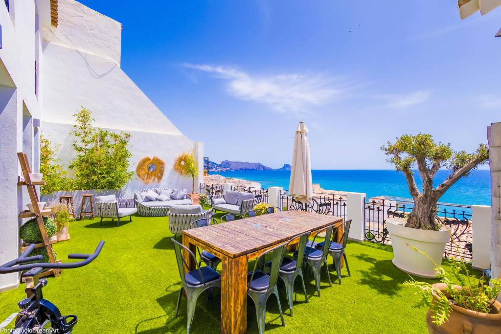 eine Terrasse mit einem Tisch, Stühlen und Meerblick in der Unterkunft MIMAR ALTEA SOL urban in Altea