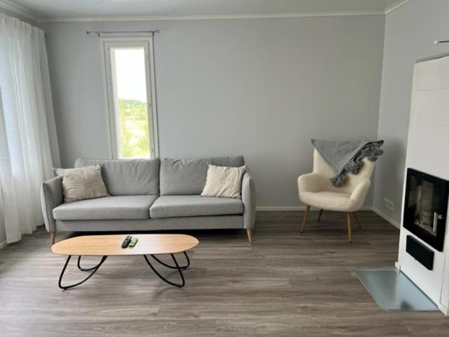 uma sala de estar com um sofá e uma mesa de centro em Soda Home - Hillside House - 24h check in em Närpiö