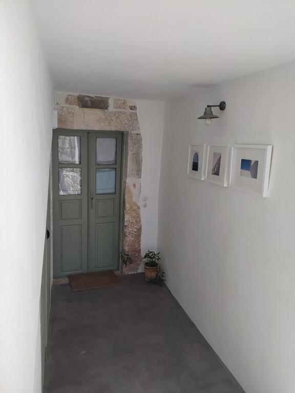 a hallway with a green door in a room at Latmos 1860 in Skala