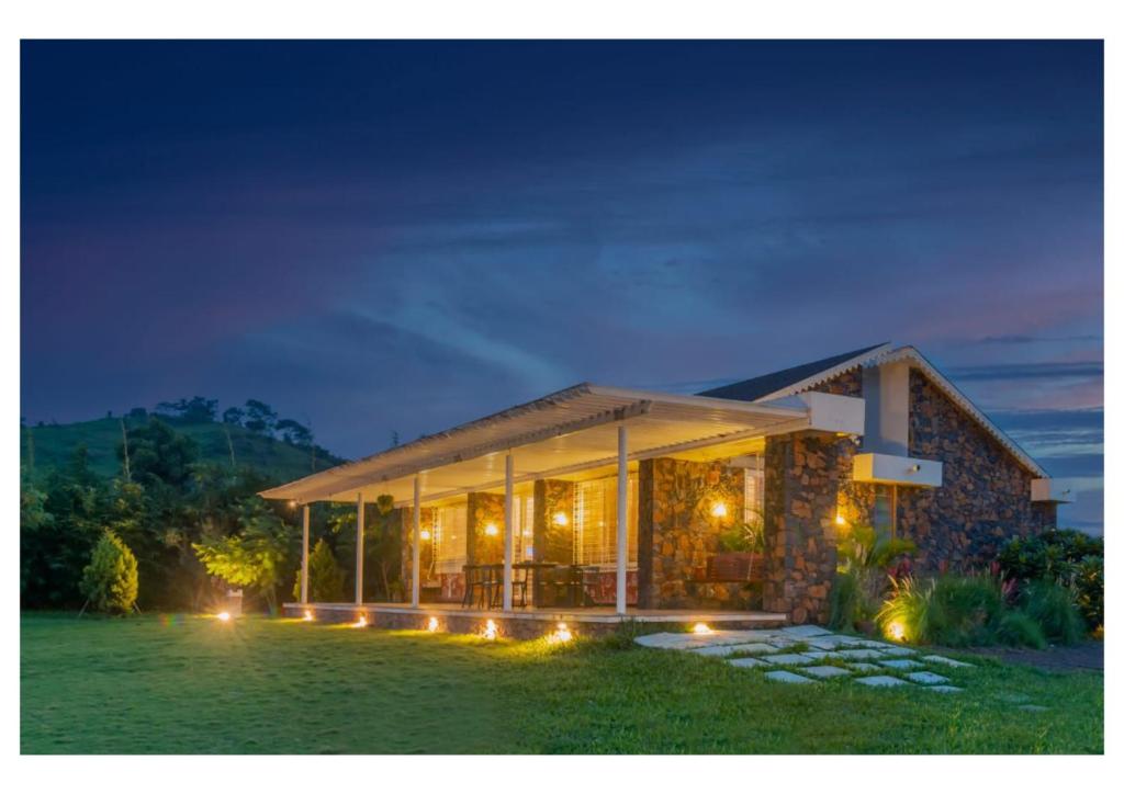 a house with lights in the grass at night at Stone Cold 2BHK in Nashik