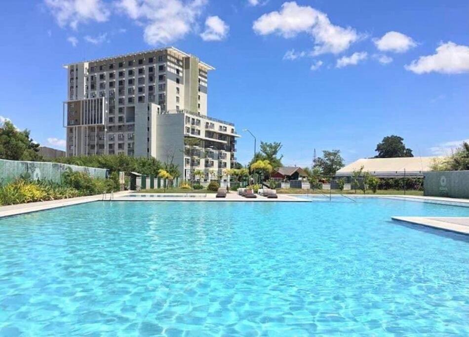una gran piscina con un edificio en el fondo en NEW Luxury Suite with pool and Netflix near Airport, en Marigondon