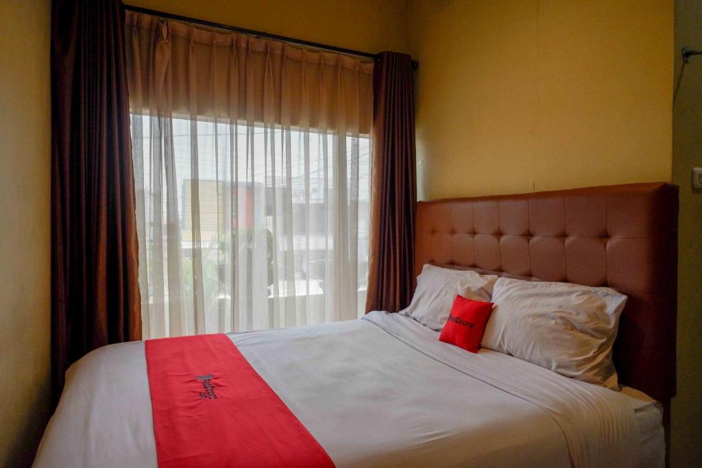 a bedroom with a large bed with a window at RedDoorz near Rumah Sakit Ortopedi Dr Soeharso in Solo