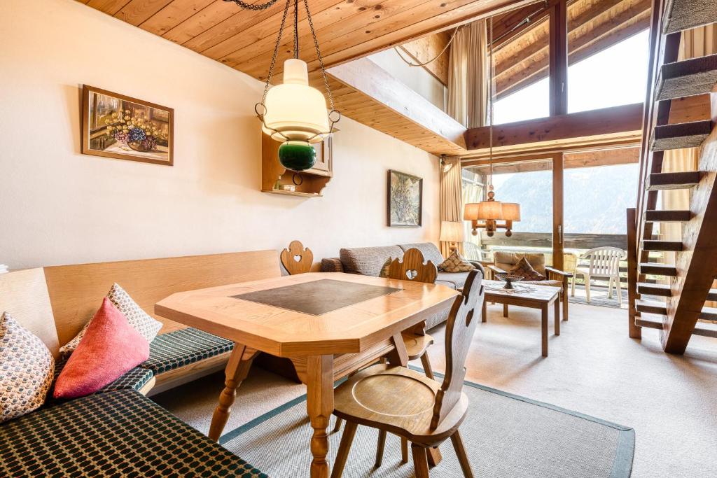 施倫斯的住宿－Retrowohnung mit Bergpanorama by A-Appartments，客厅配有木桌和椅子