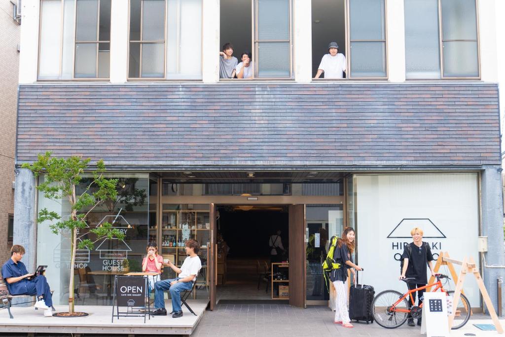grupa ludzi stojących przed budynkiem w obiekcie オランドの二階 w mieście Hirosaki