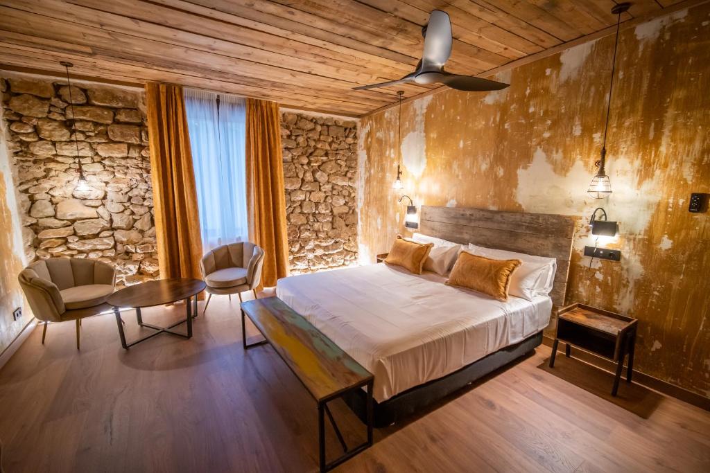 una camera con letto, tavolo e sedie di HOTEL SOMNIFABRIK a Valderrobres