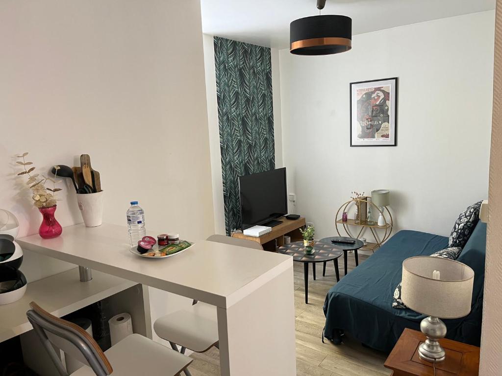 ein kleines Wohnzimmer mit einem Tisch und einem Sofa in der Unterkunft La Ruelle des Bords de Loire - Classé 2** in Basse-Indre