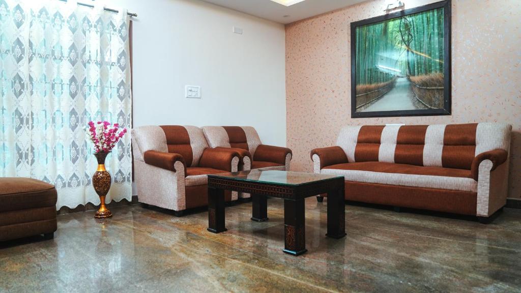 a waiting room with couches and a table in a room at Padmanivas in Bangalore
