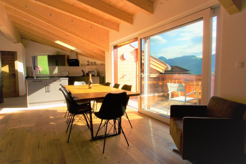 eine Küche und ein Esszimmer mit einem Tisch und einem großen Fenster in der Unterkunft Mountain Penthouse Top 8 & 9 in Fügen