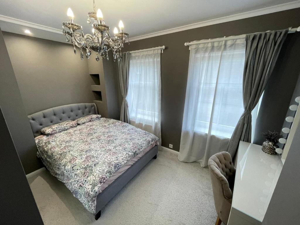 - une chambre avec un lit et un lustre dans l'établissement Brother street apartment, à Liepāja