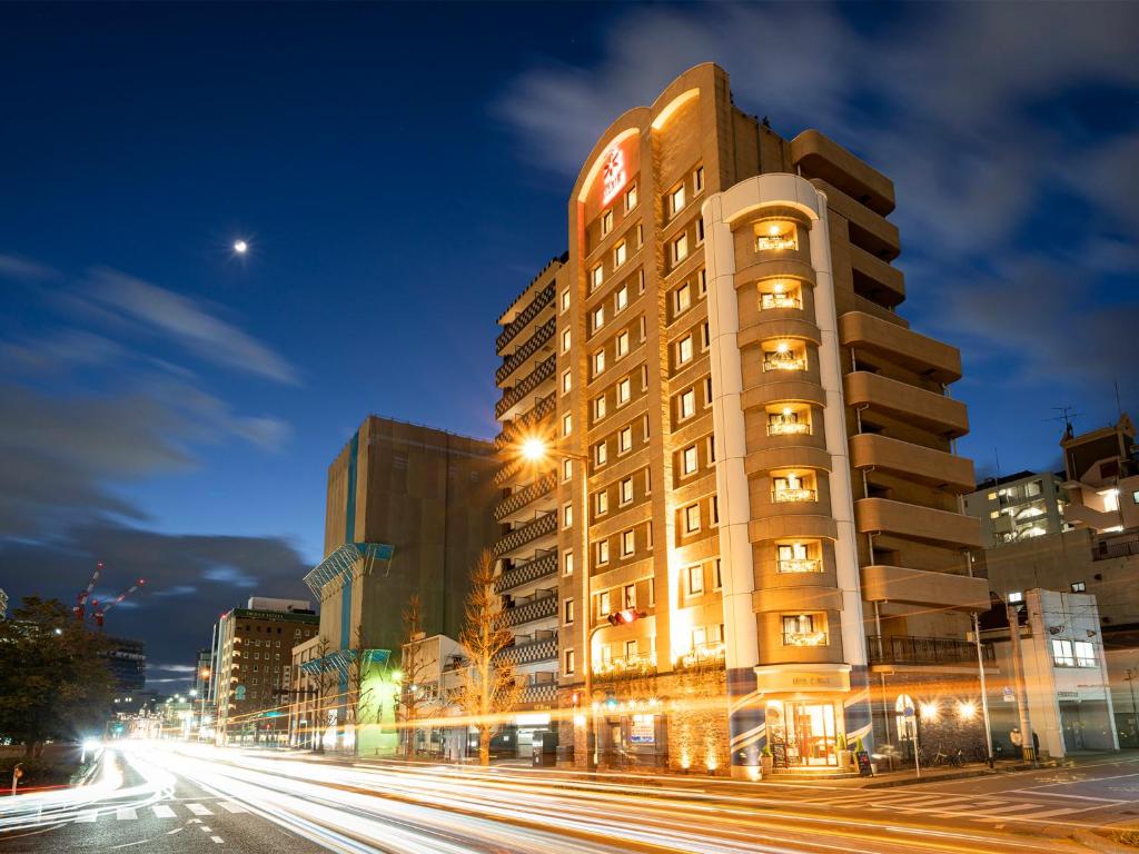 un edificio alto en una calle de la ciudad por la noche en Hotel Eclair Hakata, en Fukuoka