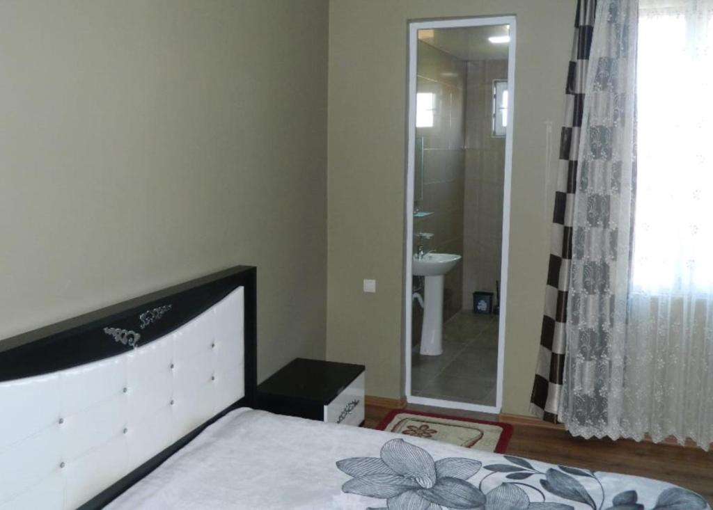 ein Schlafzimmer mit einem Bett, einem Waschbecken und einem Spiegel in der Unterkunft Kobuleti Deluxe Apartments with Sea View in Kobuleti