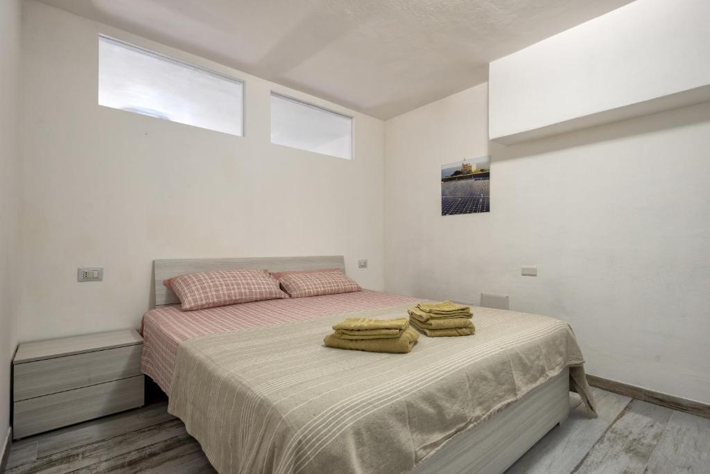 a bedroom with a bed with yellow towels on it at Solelio in Alghero