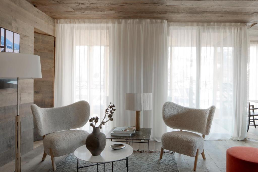 a living room with two chairs and a table at HOTEL de LEN in Cortina dʼAmpezzo