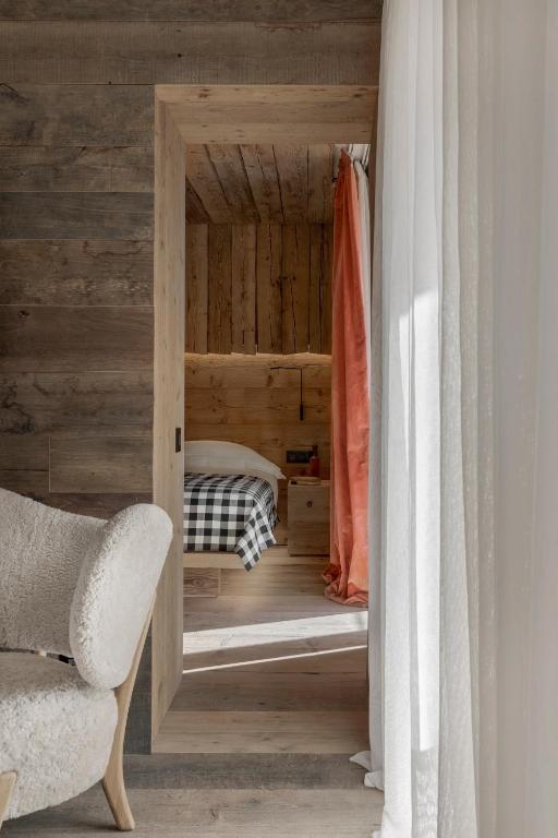 a small bedroom with a bed in a wooden wall at HOTEL de LEN in Cortina dʼAmpezzo