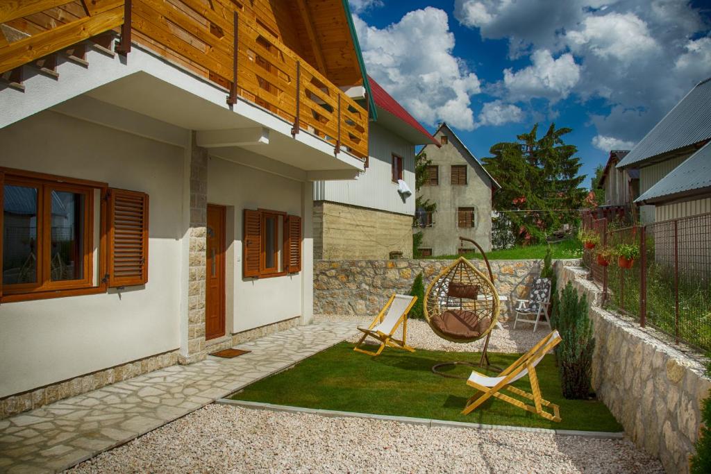 a patio with two chairs and a house at Monte Pino Lux Apartments in Žabljak
