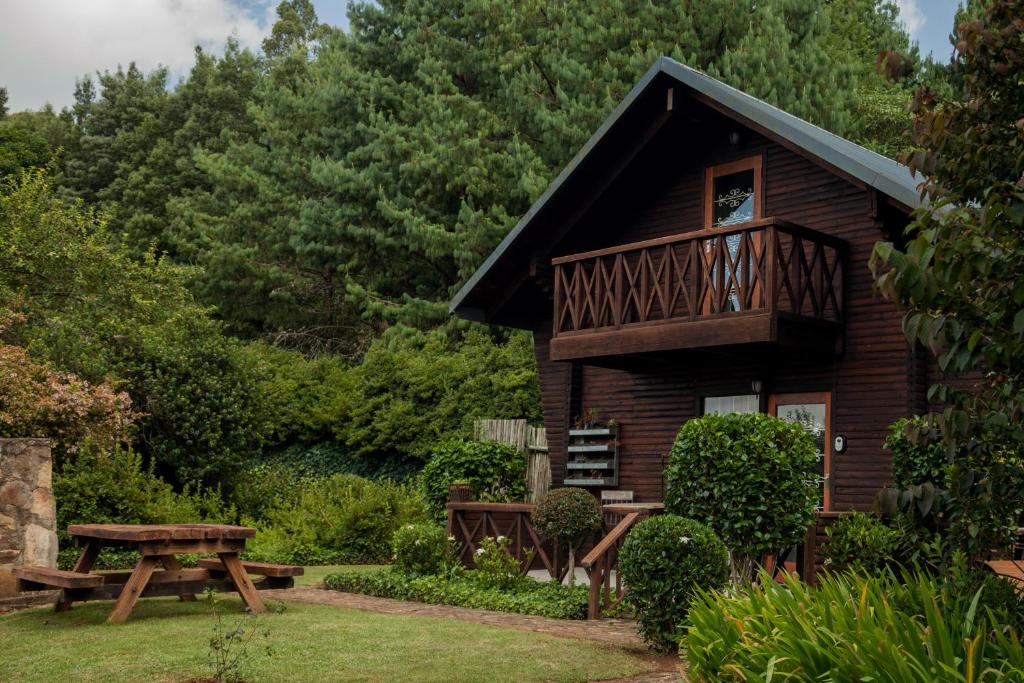 a log cabin with a deck and a picnic table at Viewpoint Cabin 7 in Haenertsburg