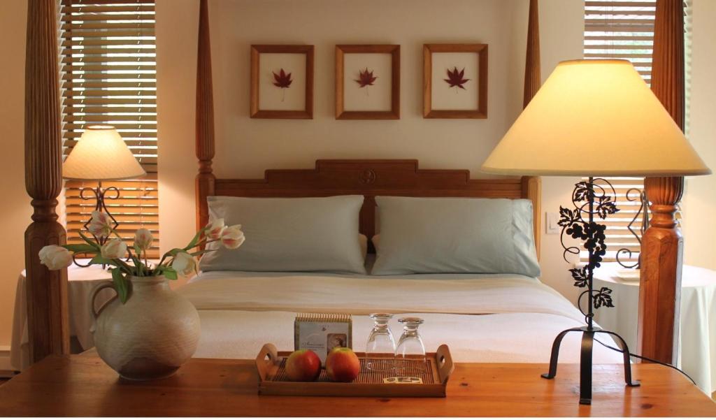 a bed with two lamps and a tray of fruit on a table at Shawnigan Lake Bed and Breakfast in Shawnigan Lake
