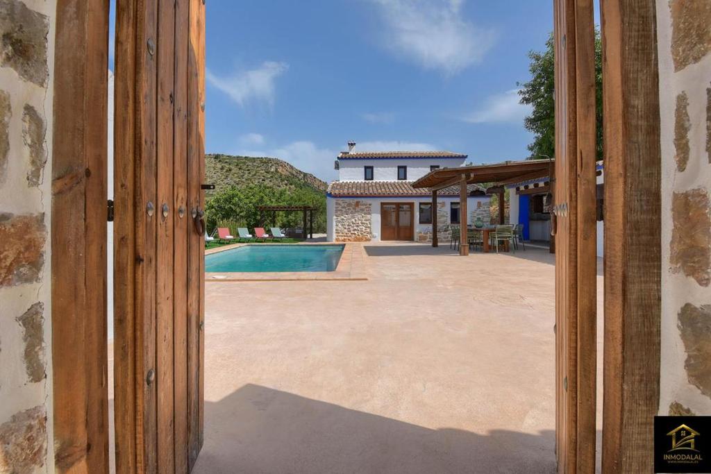 une porte ouverte menant à une arrière-cour avec une piscine dans l'établissement Casa Romero, à Benissa