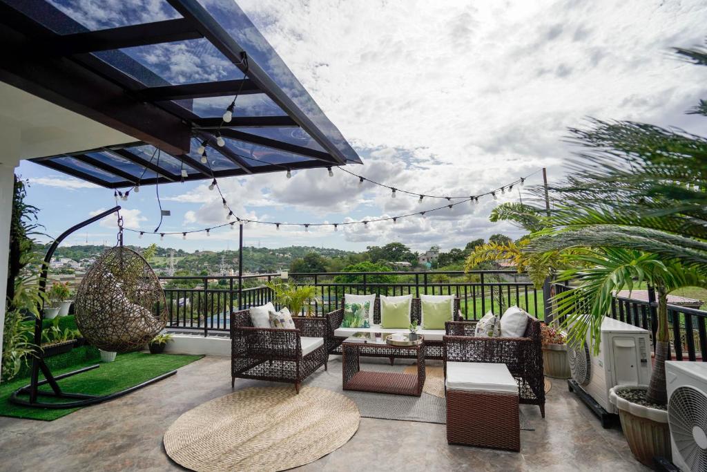 eine Terrasse mit Stühlen und Tischen auf dem Balkon in der Unterkunft JMO Apartments in Antipolo