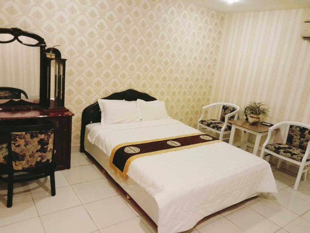 1 dormitorio con 1 cama, mesa y sillas en HOTEL Bồ Câu, en Can Tho
