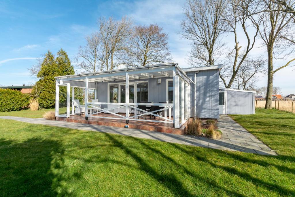 a tiny house in a field with grass at Eureka 75 Sint Maartenszee in Sint Maartensvlotbrug