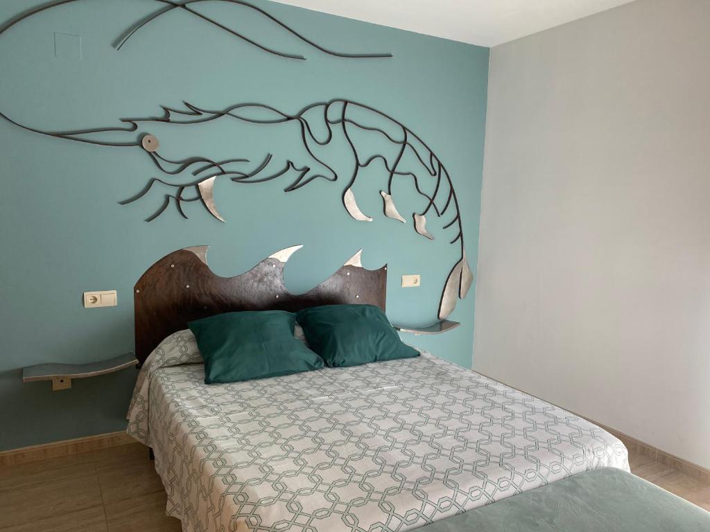El Piset del Llangosti في فيناروس: غرفة نوم مع سرير مع فيش على الحائط