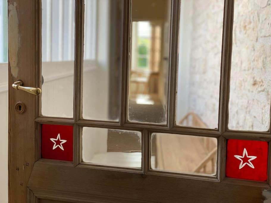 - une porte en bois avec des étiquettes rouges et blanches dans l'établissement Élégante maison de village au cœur de La Noue, à Sainte-Marie de Ré