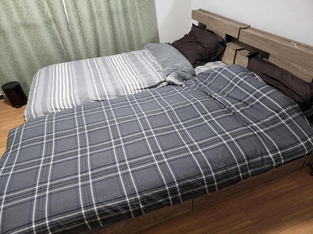 a bed with a blue and white plaid w obiekcie Jinpachi Building - Vacation STAY 64315v w mieście Gifu