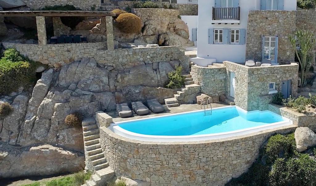 an image of a swimming pool in a rock wall at Villa Azurite with heated pool by Diles Villas in Psarou