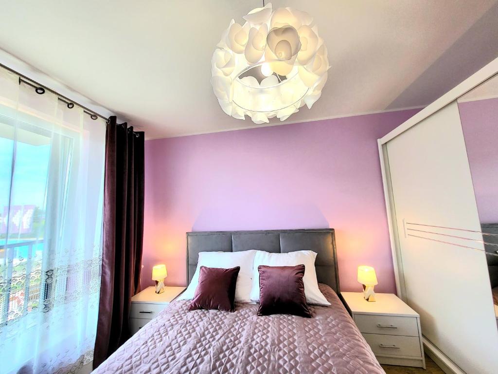 um quarto roxo com uma cama e um lustre em Eksclusive Apartment PARADISE DOWN TOWN 6 persons 3 rooms em Cracóvia