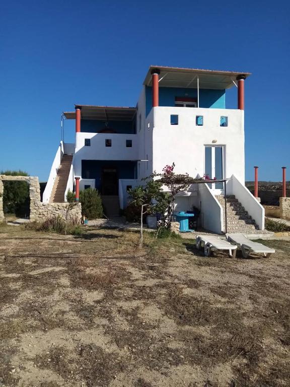 een wit huis met een trap ervoor bij Villa Hellas in Afiartis