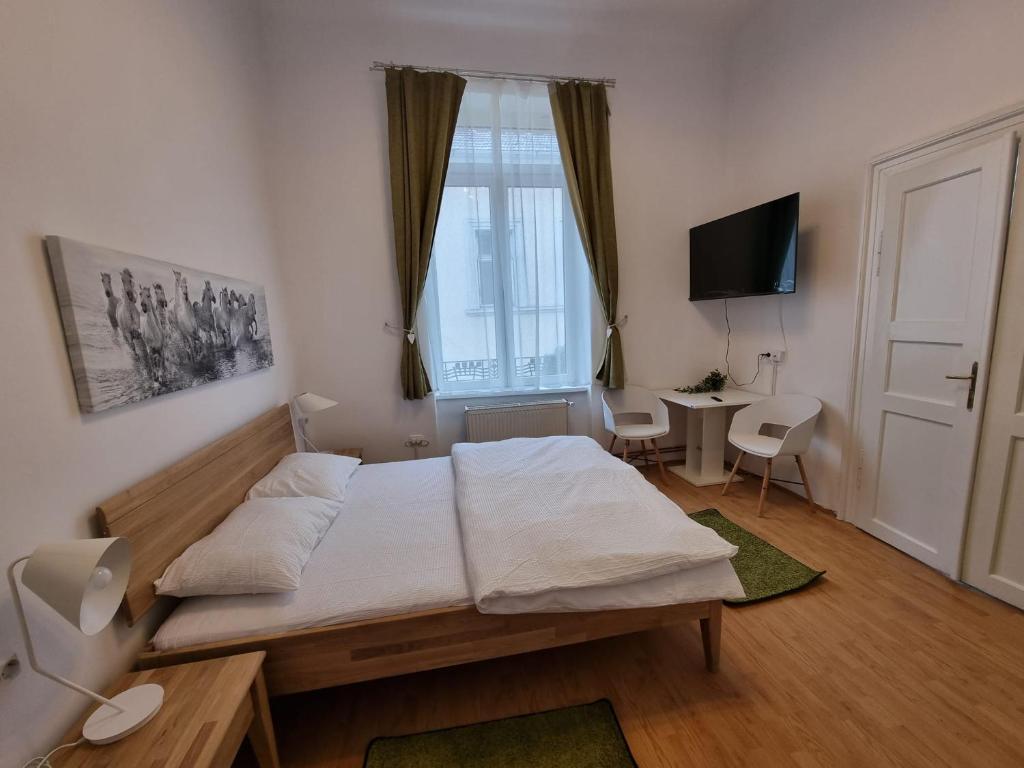 a bedroom with a bed and a desk and a window at Central Park Apartments in Cluj-Napoca