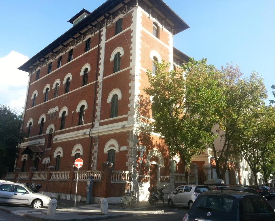 a large brick building with cars parked in front of it at Suites Farnese Design in Rome