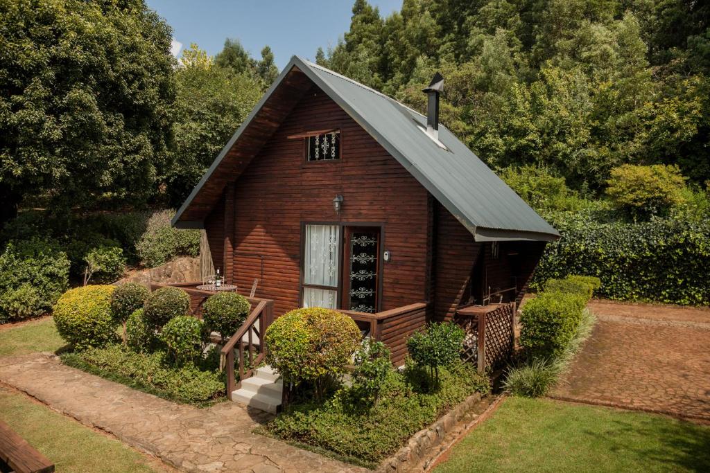una pequeña casa de madera con techo en Viewpoint - Cabin 4, en Haenertsburg