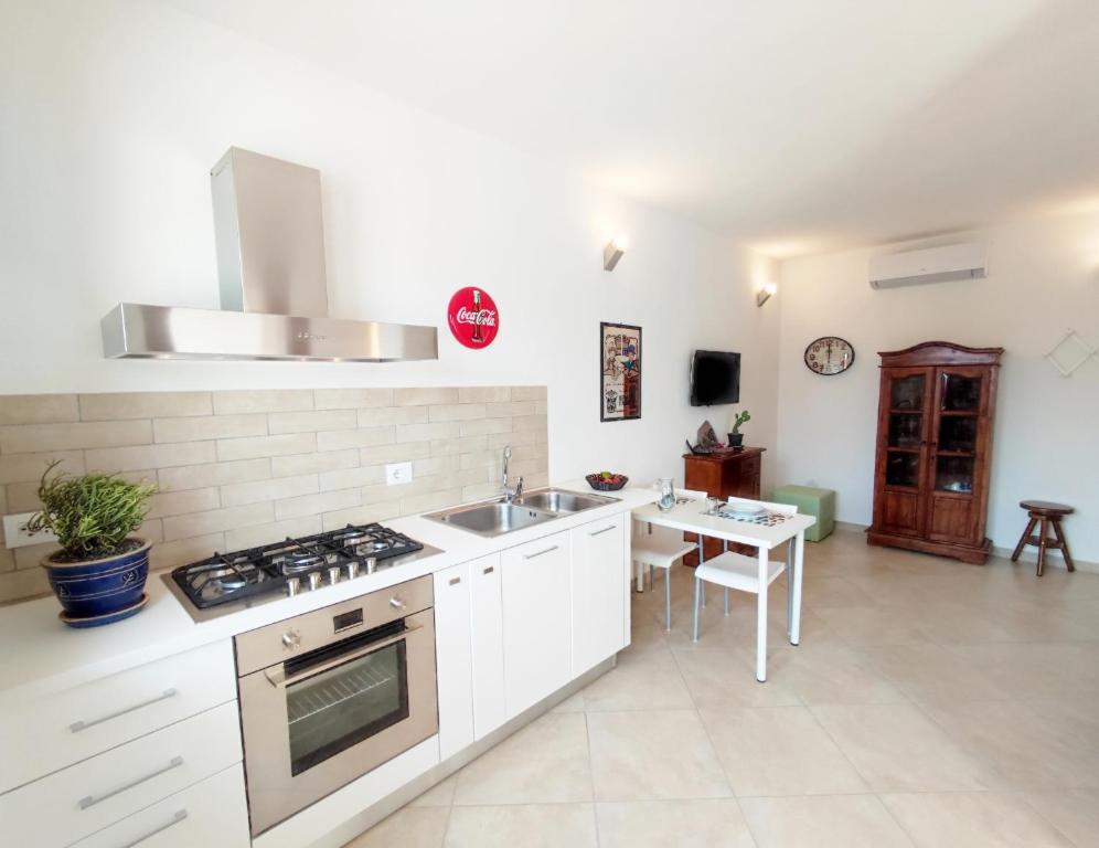 uma cozinha com um lavatório e um fogão forno superior em Casa Vacanza Luna em SantʼAntìoco