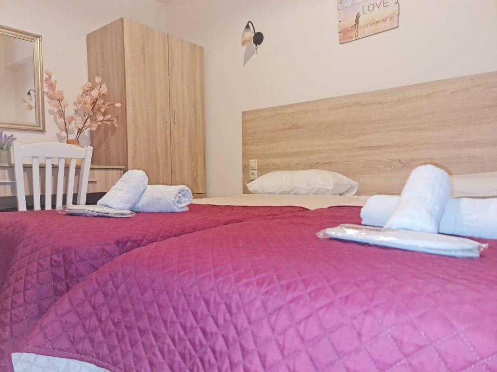 a bedroom with two beds with purple blankets at Agnes Rooms in Pelekas