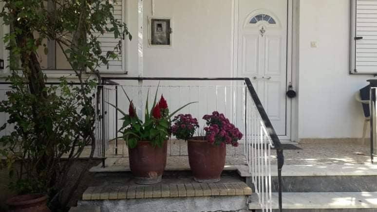 dwie doniczki siedzące na poręczy przed drzwiami w obiekcie Vacation House Dionysia w mieście Ejo
