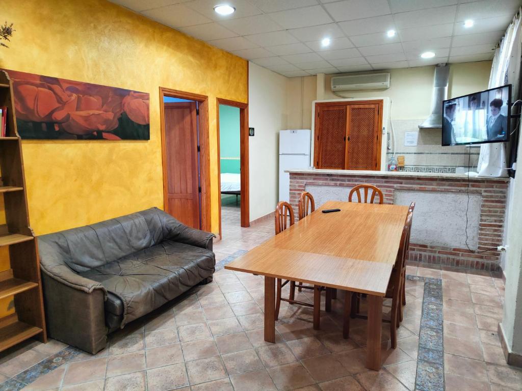 La Venta de las Estrellas Casas Rurales في فالديبينياس: غرفة معيشة مع طاولة وأريكة