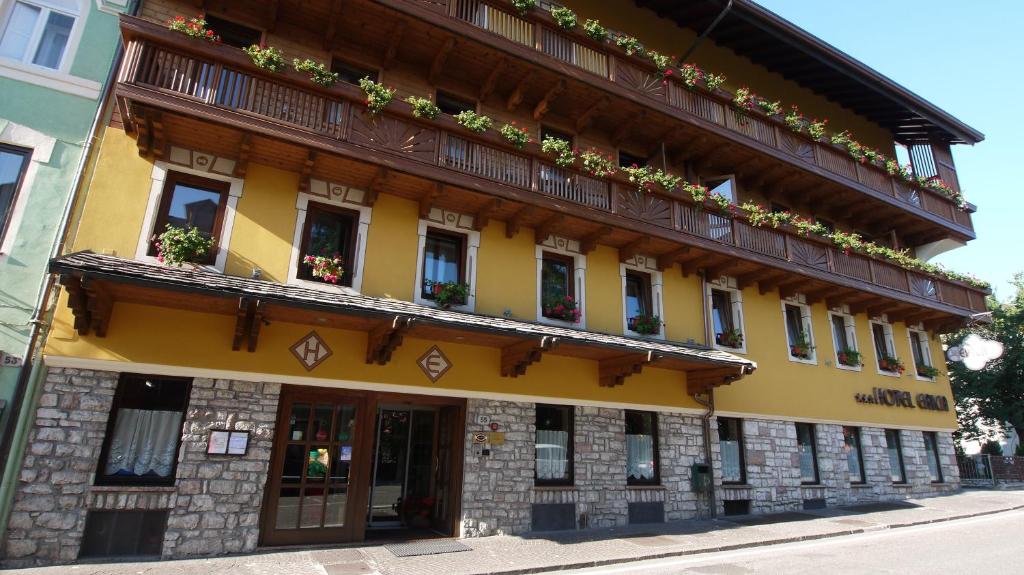 a yellow building with potted plants on it at Relax Hotel Erica in Asiago