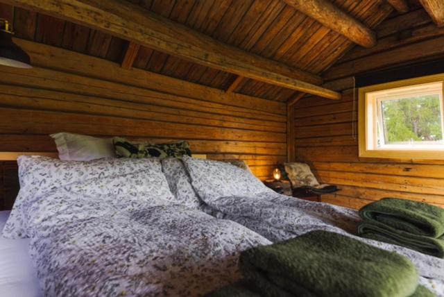 a bedroom with a bed in a log cabin at Stokke Gård Burglamping in Stjoerdal
