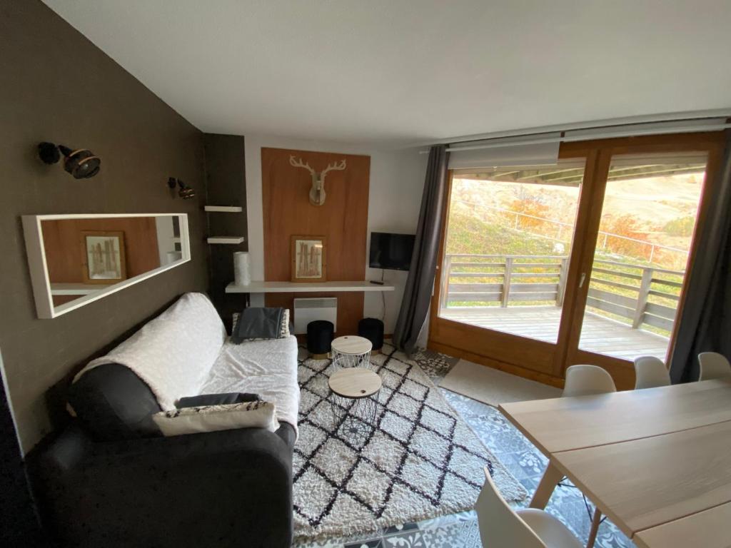 a living room with a couch and a table at Spacieux & Chaleureux Apt avec vue panoramique in Orcières