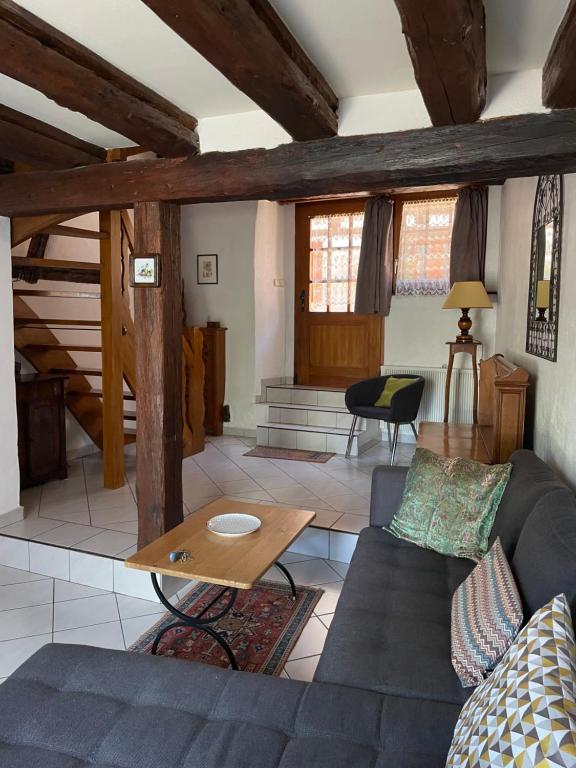 Gîte Le Hissala في اجويشيم: غرفة معيشة مع أريكة وطاولة
