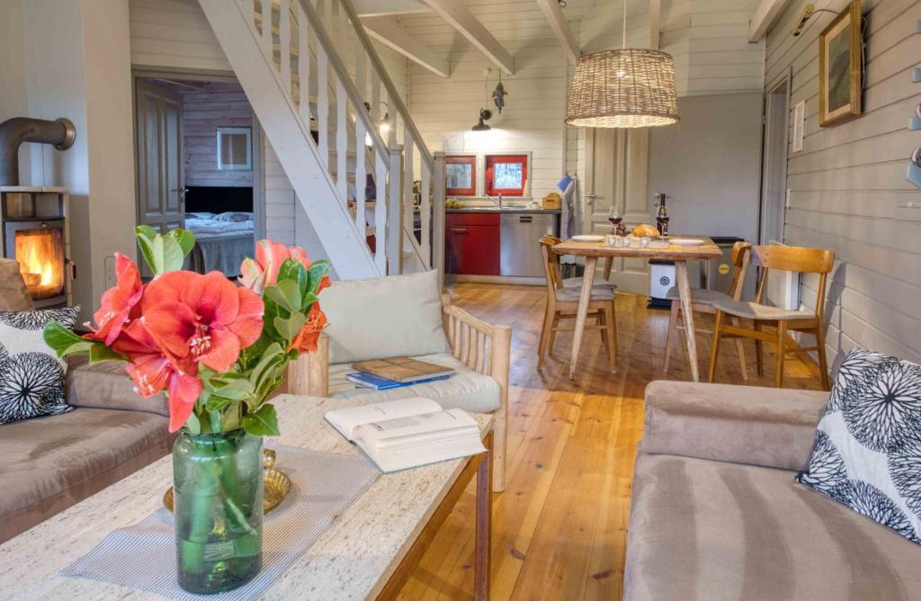 a living room with a vase of flowers on a table at traumHaff - Sea Hideaway Ostsee Region - privates NORDICSPA, Kamin, Kunst, Hund 300m zum Strand in Rieth