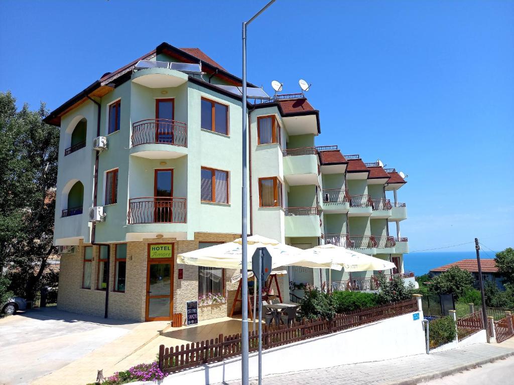 a large building with umbrellas in front of it at Family Hotel Amore in Byala