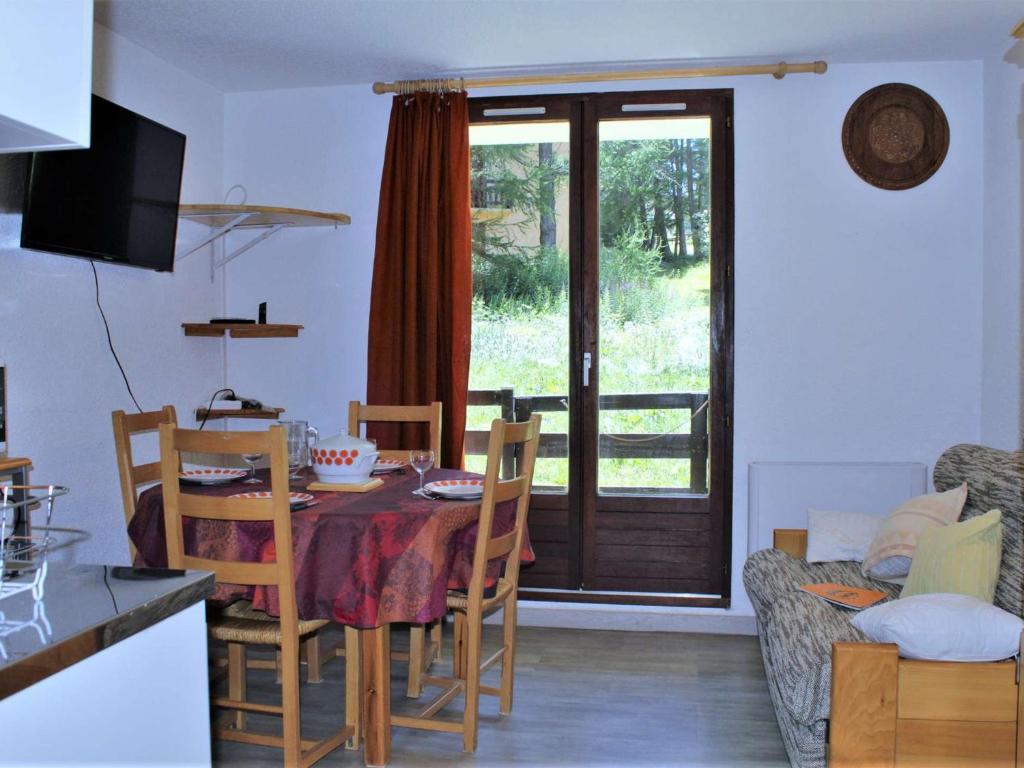 une salle à manger avec une table et des chaises et une fenêtre dans l'établissement Appartement T2 calme avec balcon sud, parking gratuit, navette proche - 4 couchages à Risoul 1850 - FR-1-330-520, à Risoul