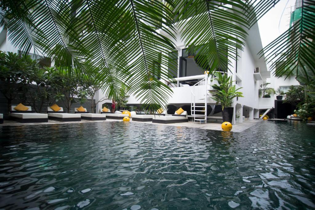 a swimming pool in a hotel with a palm ceiling at Arthur & Paul (Men Only Hotel) in Phnom Penh