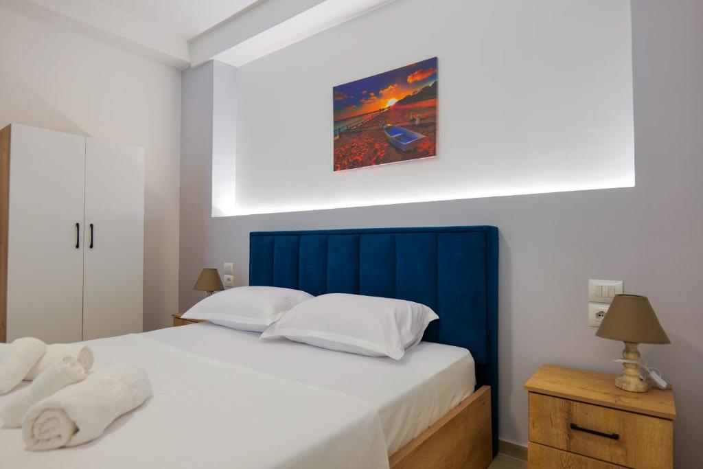 a bedroom with a large bed with a blue headboard at Twins Hotel in Ksamil