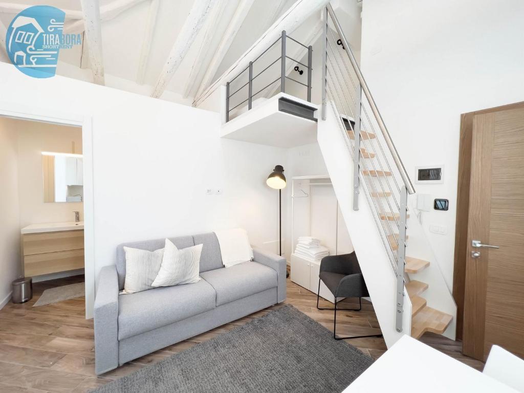 a living room with a couch and a staircase at Basovizza 3 Nicole Tirabora Short Rent in Villa Opicina