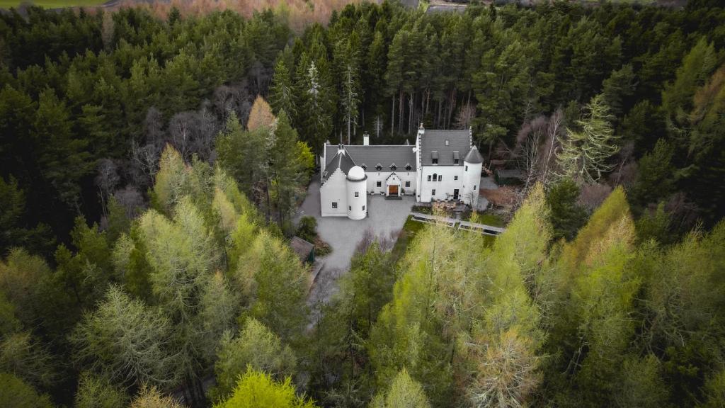 a large white house in the middle of a forest at White Rose Tower in Invergordon