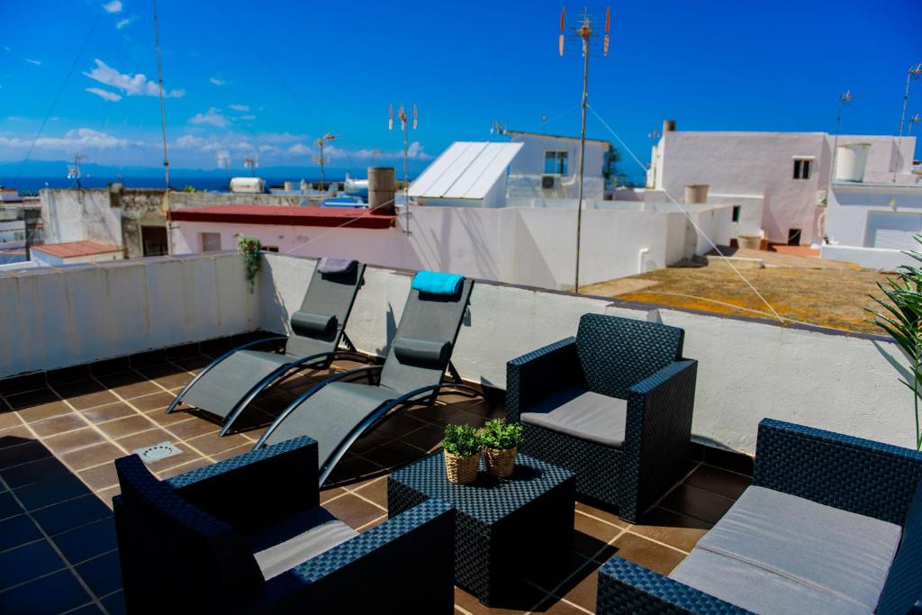 un grupo de sillas y una mesa en el techo en Livingtarifa Apartamento Bianco, en Tarifa